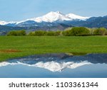 Longs Peak reflects in the waters along a country road in Longmont Colorado