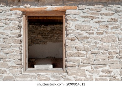 Longstreet Cabin Window Wooden Window Frame coated with white alkali dust from a nearby salt marsh. Gray rustic stonework wall and white mortar.