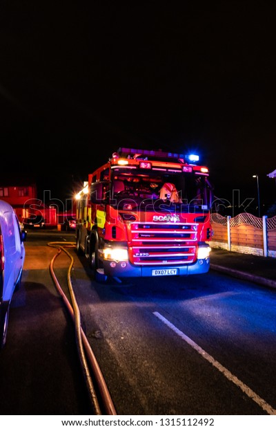 Longton, Stoke on Trent, Staffordshire - 16th\
February 2019 - Fire engines and firemen attend an emergency house\
fire on a quiet housing estate in the city caused by a fault\
washing machine wiring