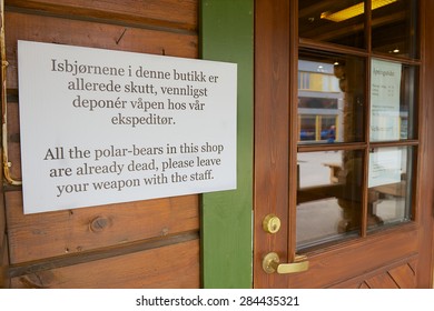 LONGYEARBYEN, NORWAY - SEPTEMBER 01, 2011: Information Sign At The Entrance To The Souvenir Shop Instructing Not To Enter With Weapons In Longyearbyen, Norway.