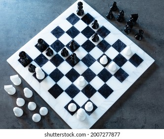 A Look From Above Of A Chess Game Going On. The Blue Hour Light Come From A Side Window.
