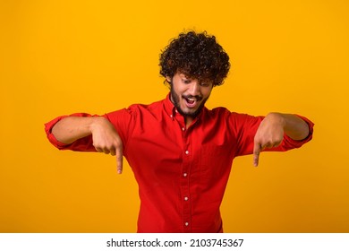 Look, Advertise Below. Cheerful Guy Pointing Down Place For Commercial Idea, Looking Down With Toothy Smile. Studio Shot Isolated On Orange Background