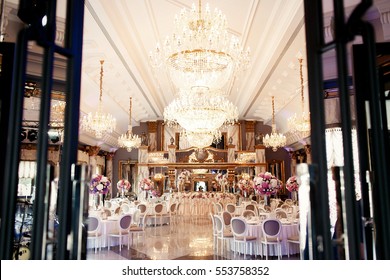 Look from afar at luxurious restaurant hall prepared for wedding dinner