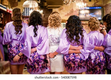 Look From Behind At Bride And Bridesmaids In Violet Robes