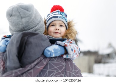 Look from behind at little boy hugging father's neck