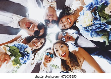 Look from below at newlyweds and friends hugging outside