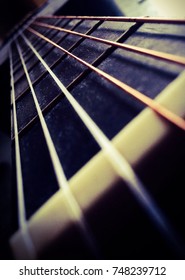 A look down the strings of a six string acoustic guitar