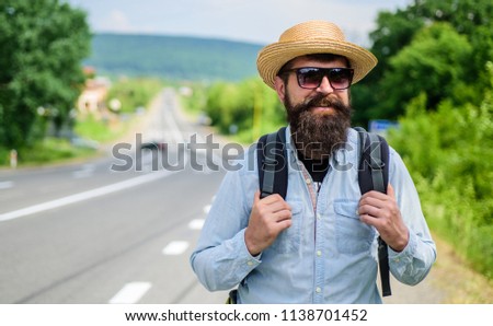 Look for fellow travelers. Tips of experienced tourist. Man bearded hipster tourist at edge of highway. Looking for company. Tourist waiting for car take him anyway just drop at better spot.