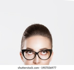 Look Up Here. Closeup Brunette Smart Young Woman Pretty Girl Face Above Nose In Eye Glasses Having Idea Looking Up At Blank Copy Space Retro Vintage Hairstyle. Body Language