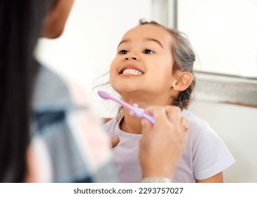 Look at how theyre shining. Shot of a mother helping her little daughter brush her teeth in the bathroom at home. - Powered by Shutterstock