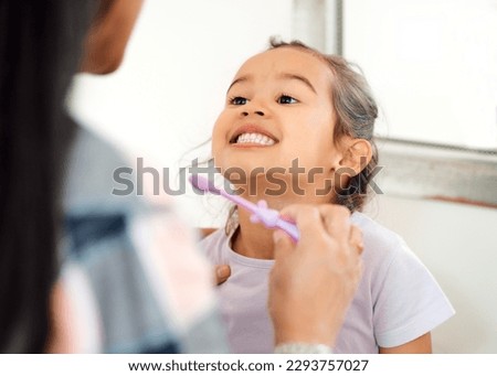 Look at how theyre shining. Shot of a mother helping her little daughter brush her teeth in the bathroom at home.