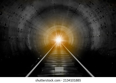A look into a station tunnel. Fast underground train riding in a tunnel. Subway, underground, crossing in the tunnel, with front lighting