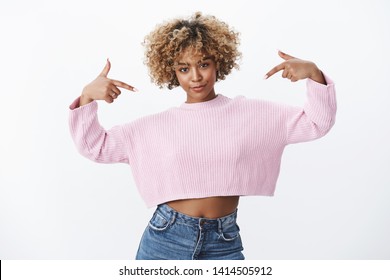 Look at me. Portrait of confident and charismastic african-american young woman in stylish cropped sweather with pierced nose and afro blond hair smirking delighted and assured as pointing at herself - Shutterstock ID 1414505912