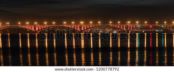 Look on the bridge\
through the Yenisei River in Siberia, Russia, shooting at night,\
noise, soft focus