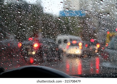 Look on wet city through windshield from inside the car at rain weather 