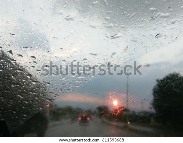 Look on wet city through windshield from inside\
the car at rain weather
