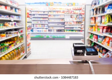 Look Out From The Payment Counter, Blur Image Of Snacks And Drinks On The Shelves In The Convenience Store As Background.