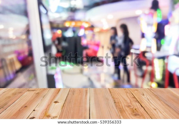 Look out from the table, blur image of game\
zone in the mall as\
background.