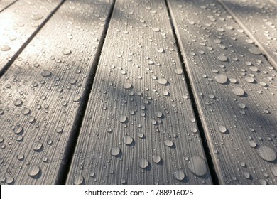 A look at the perspective of gray plastic slats. The surface has an imitation of the wood texture. There are drops of water after the rain. Background. Texture. - Powered by Shutterstock