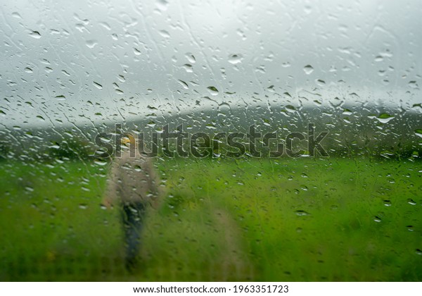 Look at the rain outside from inside the car.\
Raindrops are pouring down the\
window.