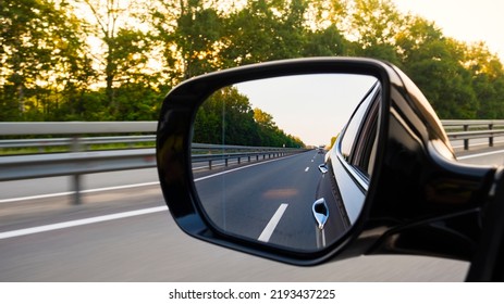 Look in the rear view mirror of a car. Car driving on the road. - Powered by Shutterstock