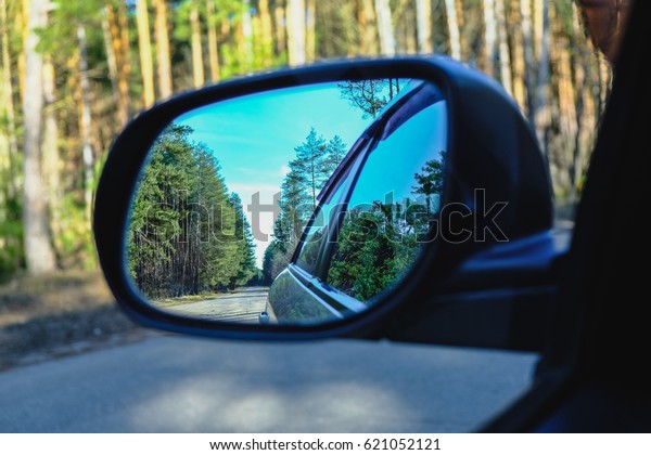 look in the rear view\
mirror of a car\

