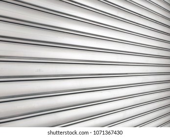 Look From The Side Of Roll-up Door, Made From Metal, Lines Of Bright Door Leading Eyes In Perspective Way, Like They Are Moving Into Center Line From Left To Right