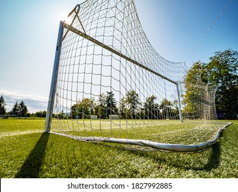 Look through net to football field in soccer stadium. Soccer field with green grass in football sport stadium behind net curtain. Sport equipment, football gate