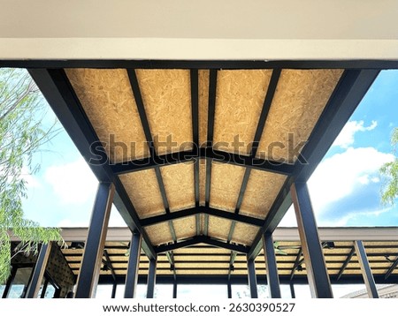 look up view of a bare ceiling which made from osb board and steel structure of a corridor