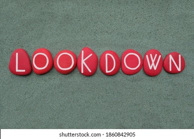 Lookdown, creative logo composed with red colored stone letters over green sand