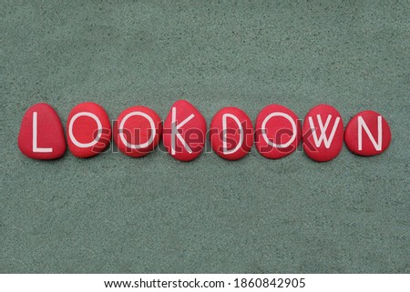 Lookdown, creative logo composed with red colored stone letters over green sand