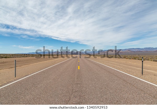 Looking\
along a long, straight road in the Nevada\
desert