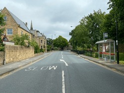Looking Along The, Main Street, With Victorian Buildings, Trees, And A Cloudy Sky In, Burley In Wharfedale, UK