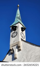 Looking up at an Austrian tower with bells and a clock
