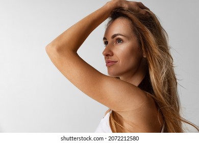 Looking Away. Close-up Portrait Of Young Beautiful Smiling Woman Without Makeup Isolated Over Light Studio Background. Wellness, Wellbeing, Fitness, Cosmetics, Dental Health Concept. Natural Beauty