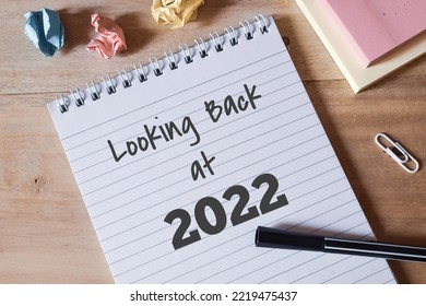 Looking back at 2022 text in notepad on desk. Highlights and overview for the year 2022 concept. Close up image, top view.  - Shutterstock ID 2219475437