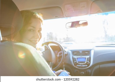 Looking Back And Sitting Inside Of Car Woman With Sun Rays In Window