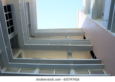 Looking up in building with empty blue sky.