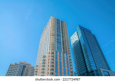 Looking up at building exterior at a residential complex in Austin Texas. Modern city skyline with offices or condominiums against a cloudless blue sky background.