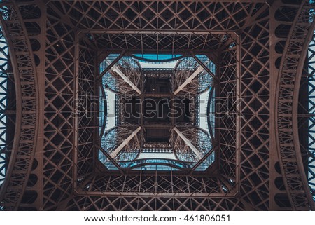Looking up the center of the Eiffel Tower, Paris in a symmetrical view showing the structure of the wrought iron lattice in a travel and engineering concept