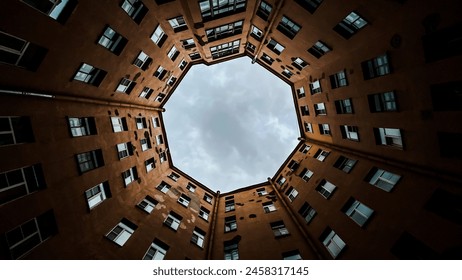 Looking up at circular courtyard of an old apartment building with an octagonal sky view. Urban architecture - Powered by Shutterstock