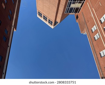 Looking up at a clear blue sky surrounded by generic buildings on three sides. Charlotte NC 2026