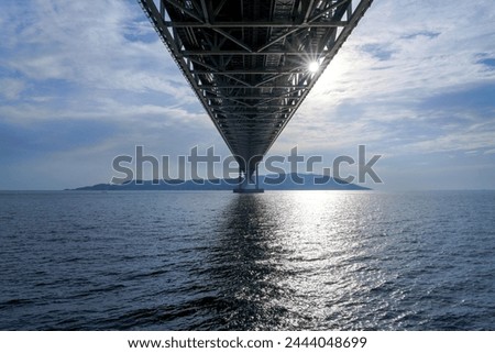 Looking up collaboration scenery of the Akashi Kaikyo Bridge and striation in the blue sky background