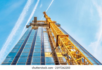 Looking Up At The Construction Site Of A High-rise Building With A Yellow Crane