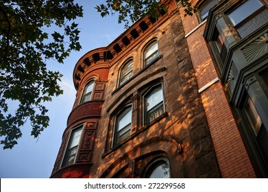looking up at the corner of a brownstone building