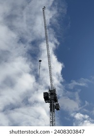 Looking up at a crane with clouds behind it