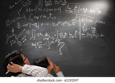 Looking at difficult complex mathematics equation on balckboard