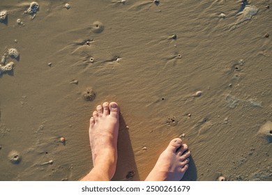 looking down at bare feet on the beach during sunset - Powered by Shutterstock