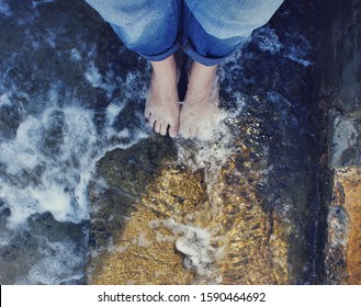 Looking Down To Bare Feet Standing Under Water Covered Surface