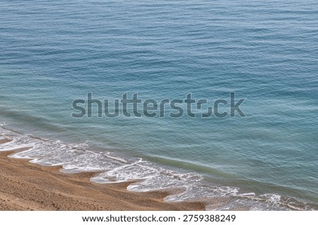Looking down at beach cusps along the Jurassic coast, on a sunny day